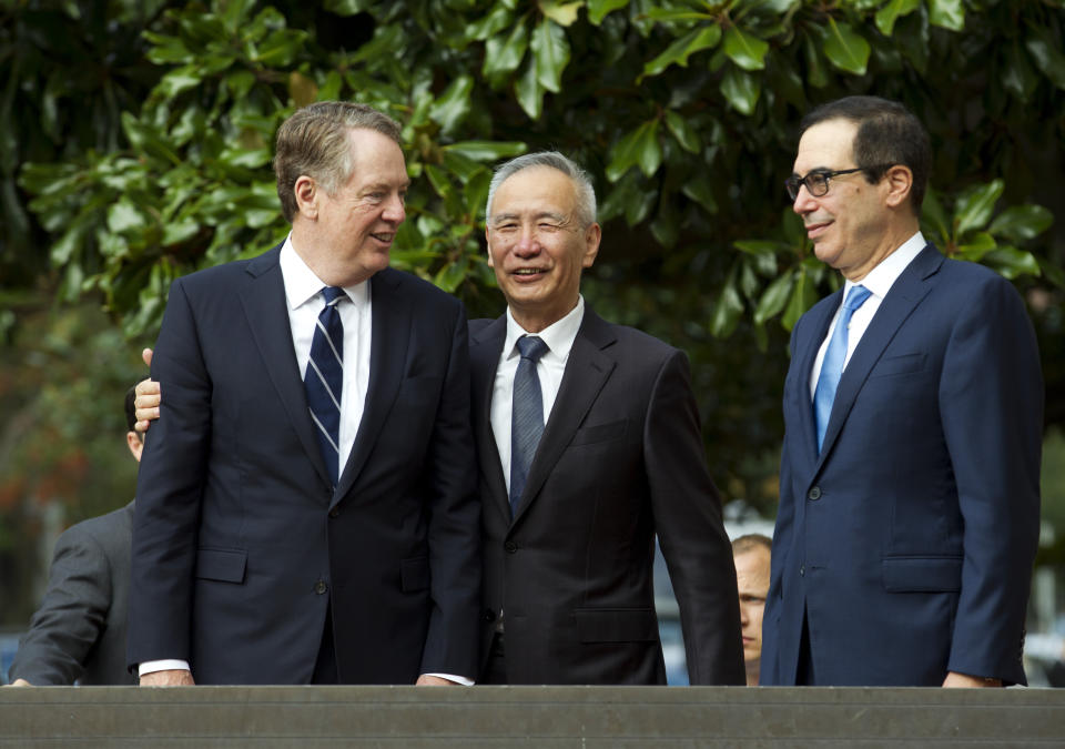Chinese Vice Premier Liu He accompanied by U.S. Trade Representative Robert Lighthizer, left, and Treasury Secretary Steven Mnuchin, greets the media before a minister-level trade meeting in Washington, Thursday, Oct. 10, 2019. (AP Photo/Jose Luis Magana)