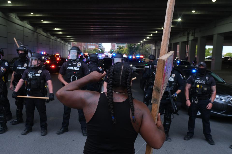 A demonstrator confronts police