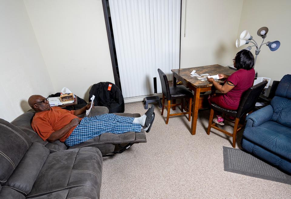 Andras King and Terene White, residents at Sycamore Place Apartments, look through receipts and notices.