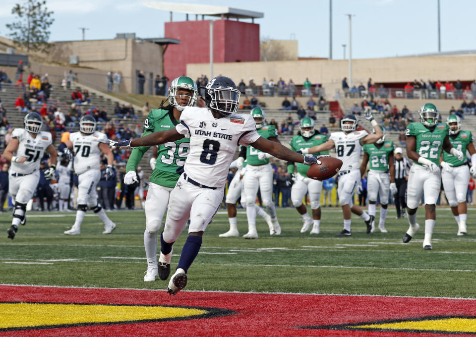 Utah State running back Gerold Bright (8) scores a touchdown ahead of North Texas defensive back Jameel Moore (39) during the first half of the New Mexico Bowl NCAA college football game in Albuquerque, N.M., Saturday, Dec. 15, 2018. (AP Photo/Andres Leighton)