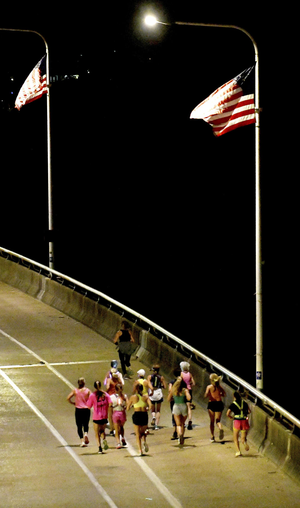 A group of runners cross the Veteran's Bridge as they return to Girls Preparatory School as they take part in "Finish Eliza's Run" on Friday, Sept. 9, 2022 in Chattanooga, Tenn. The approximately four mile run was to memorialize, Eliza Fletcher, the Memphis runner, and mother of two, who was murdered during her early morning run. (Robin Rudd /Chattanooga Times Free Press via AP)