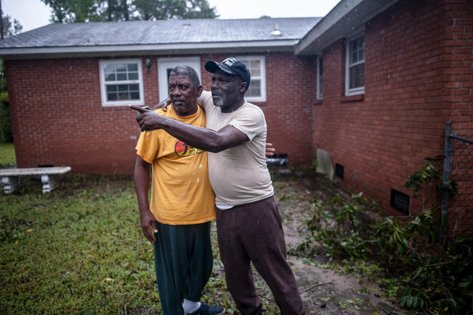 Ronnie McRae and Lorenzo Mitchell watch rising floodwaters in Lumberton, North Carolina, on Sunday.