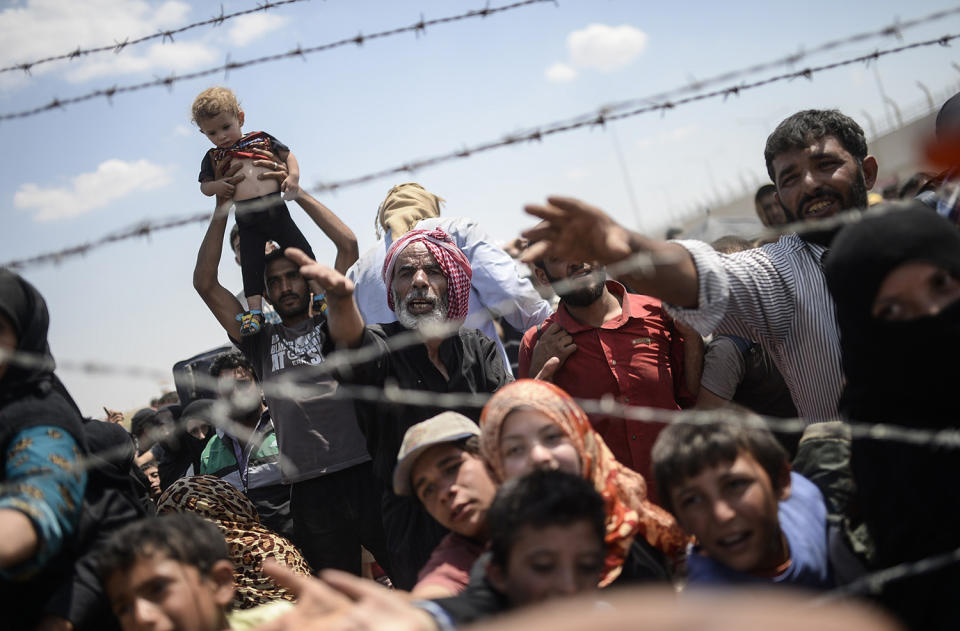 Syrians fleeing the war wait to enter Turkey near the Turkish border crossing at Akcakale in Sanliurfa province. (Photo: Bülent Kilic/AFP/Getty Images)