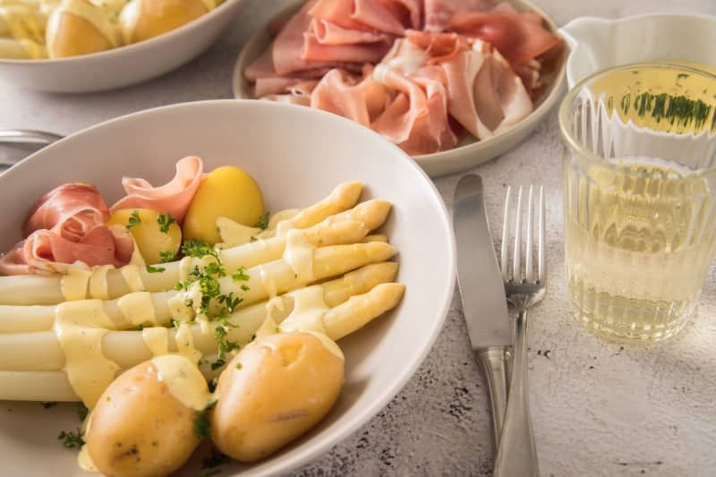 The traditional German take on asparagus looks like this - white asparagus with a creamy hollandaise sauce, potatoes and sometimes meat. It's often paired with a Riesling or Grauburgunder white wine. Christin Klose/dpa