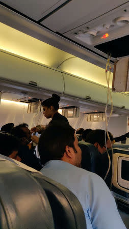 A flight attendant assists a passenger with a bleeding nose after a loss of cabin pressure, on a Jet Airways flight, from Mumbai, India September 20, 2018 in this still image obtained from social media. Melissa Tixiera via REUTERS