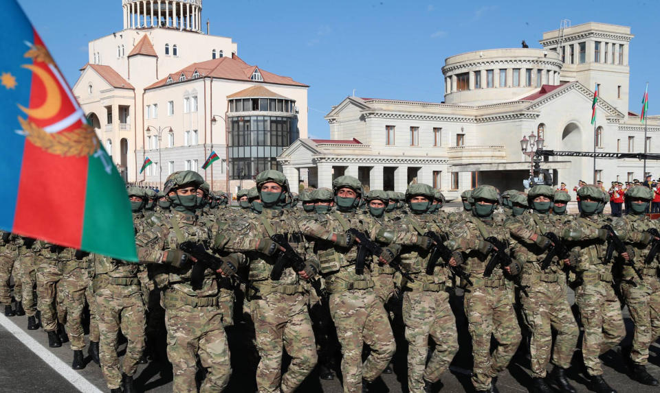 In this photo provided by the Azerbaijan's Presidential Press Office, troops march past Azerbaijani President Ilham Aliyev during a parade dedicated to the third anniversary of the Victory in the Patriotic War in Khankendi, also known by Armenians as Stepanakert, in Khankendi, Wednesday, Nov. 8, 2023. Azerbaijanis celebrate the third anniversary of their victory in the 2020 Nagorno-Karabakh war after Azerbaijan gained the full control over the separatist region in fighting earlier this year. (Azerbaijani Presidential Press Office via AP)