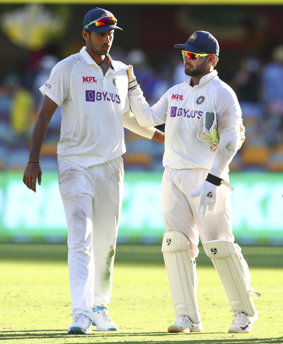 India's Washington Sundar, left, is congratulated by teammate Rishabh Pant following play on the first day of the fourth cricket test between India and Australia at the Gabba, Brisbane, Australia, Friday, Jan. 15, 2021. (AP Photo/Tertius Pickard)