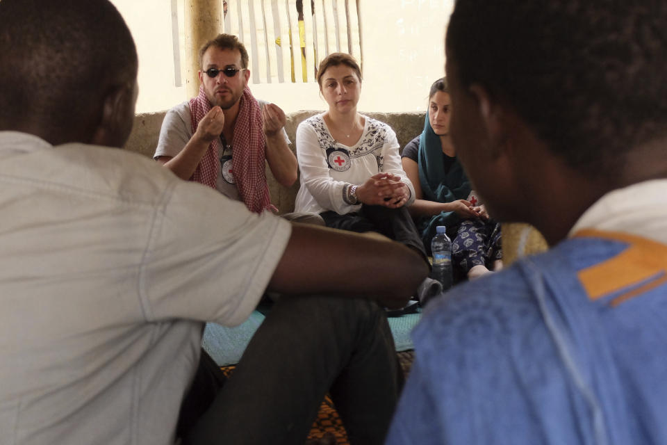 In this April 5, 2018 photo provided by the International Commission of the Red Cross, José Pablo Baraybar, forensic pathologist for the ICRC, speaks to residents of the village Melga, Mauritania, who believe they lost relatives in the April 18, 2015 shipwreck off the coast of Italy. explain their mission to gather ante-mortem data and collect DNA samples. “You cannot just tell them a story and you cannot misrepresent who you are. You're not there to bring them a body bag or give them money,” said Baraybar. (ICRC via AP)