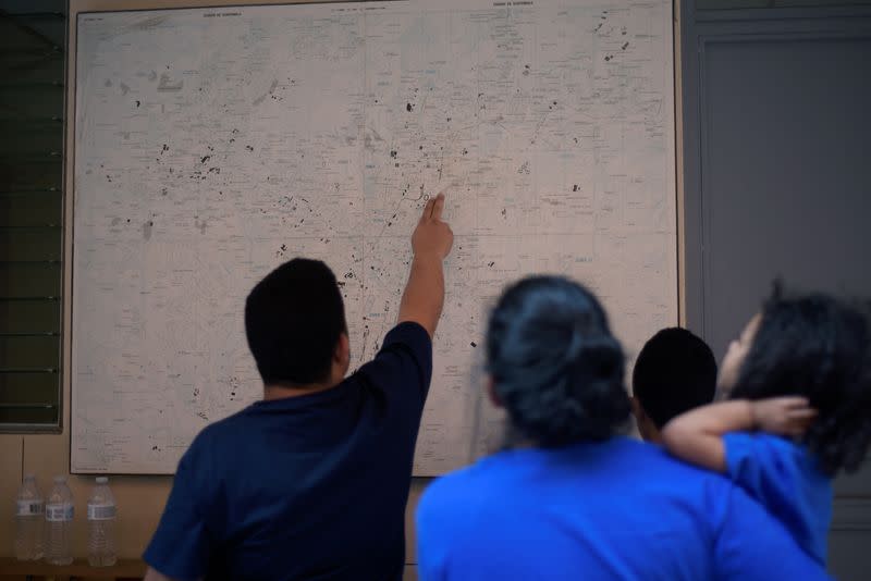 Honduran migrants, sent back to Guatemala from the United States under an Asylum Cooperative Agreement (ACA), look at a map at Casa del Migrante shelter in Guatemala City