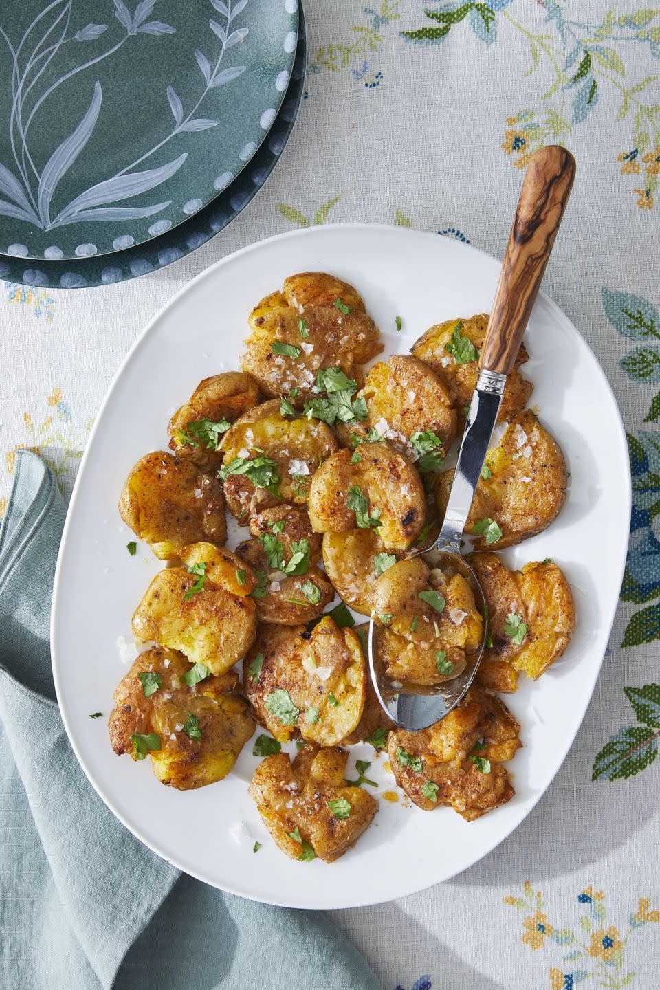 smashed potatoes with paprika and cumin on a white oval serving plate