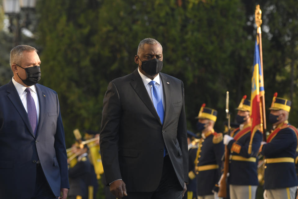 U.S. Defense Secretary Lloyd Austin, centre walks with Romanian Defense Minister Nicolae Ciuca during a welcoming ceremony, in Bucharest, Romania, Wednesday, Oct. 20, 2021. Austin is visiting Romania before attending the NATO Defense Ministerial in Brussels. (AP Photo/Andreea Alexandru)