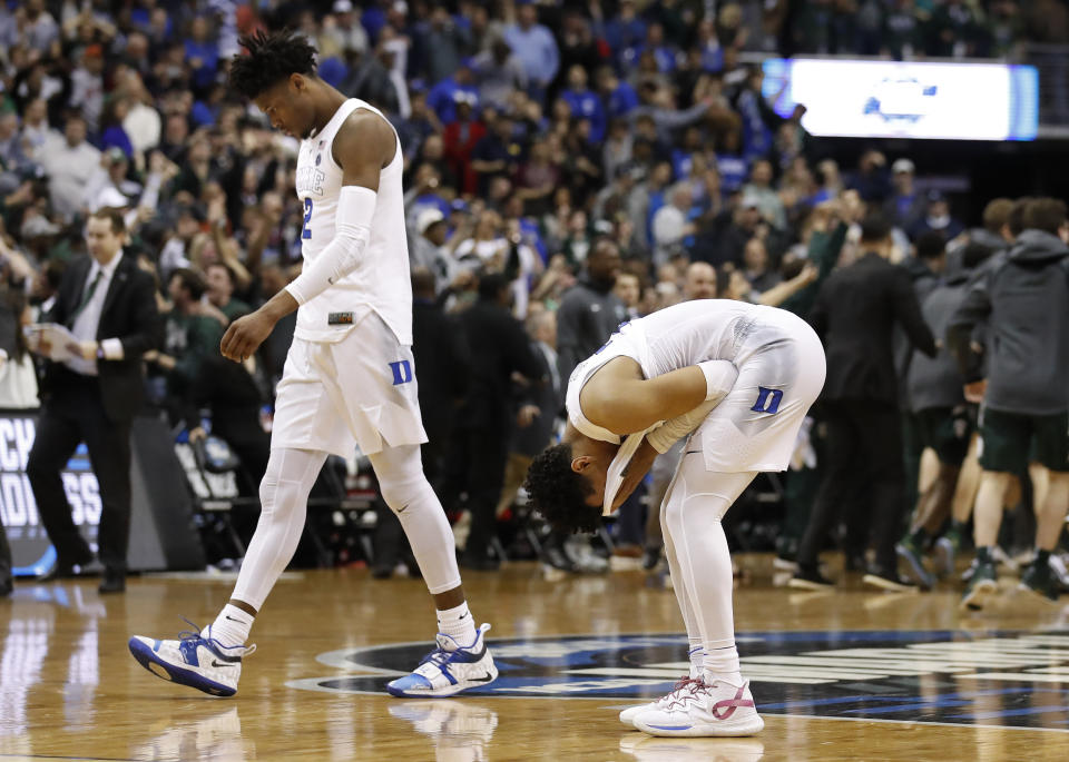 Duke forward Cam Reddish (2) walks off the court as his teammate guard Tre Jones (3) covers his face after losing to Michigan State in the NCAA men's East Regional final college basketball game in Washington, Sunday, March 31, 2019. Michigan State won 68-67. (AP Photo/Alex Brandon)