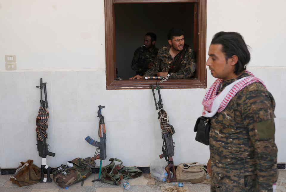 A Kurdish fighter looks out of a window in Raqqa