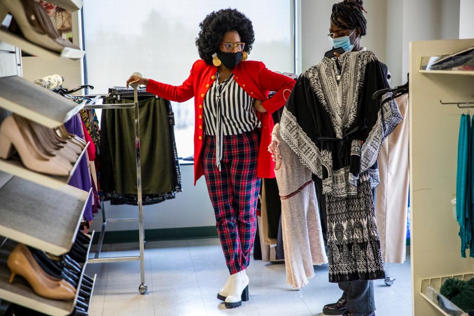 Career Coach Y. Michelle Wilson-Merriwether, of Detroit At Work, left, helps Destiny Jones, 28, of Detroit pick out work attire at Detroit At Work Partner Jackets for Jobs boutique in Detroit on Wednesday, Dec. 8, 2021.  Jackets for Jobs also provides guidance that helps people obtain sustained employment and rebuild their lives for the long term. During the holiday season, Alison Vaughn believes the best gift thousands of Detroiters can receive is sustainable employment and she is doing her best to help deliver that gift to her fellow Detroiters through her organization Jackets For Jobs.