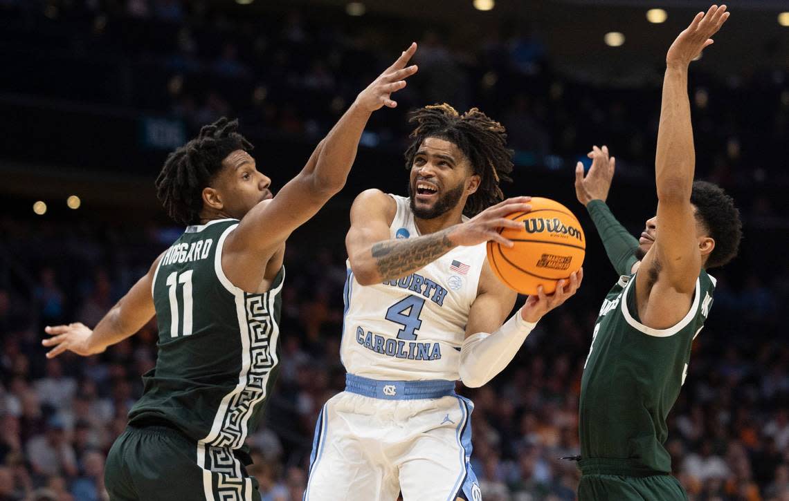 North Carolina’s R.J. Davis (4) drives to the basket against Michigan State’s A.J. Hoggard (11) and Jaden Akins (3) during the second half on Saturday, March 23, 2024, in the second round of the NCAA Tournament at Spectrum Center in Charlotte, N.C. Davis scored 20 pointing lead the Tar Heels to an 85-69 victory.