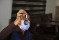 In this Friday, April 30, 2021, photo Ayazudin Hilal, 40, a former Afghan interpreter for the U.S. hold his medal during an interview to The Associated Press after a protest against the U.S. government and NATO in Kabul, Afghanistan. (AP Photo/Mariam Zuhaib)