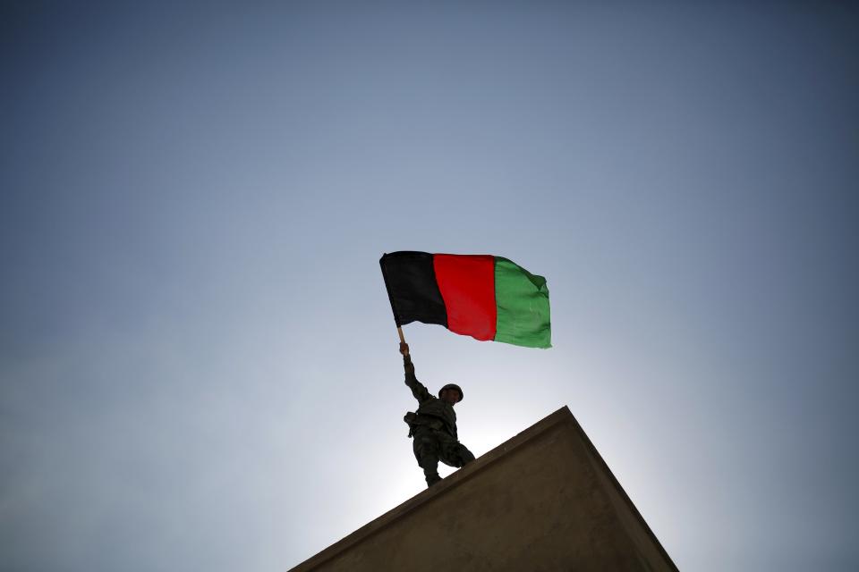 An Afghan National Army (ANA) officer holds an Afghanistan flag during a training exercise at the Kabul Military Training Centre in Afghanistan October 7, 2015. REUTERS/Ahmad Masood