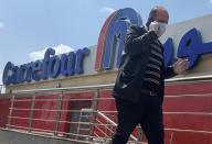 A man wearing a protective face mask walks outside a Carrefour hypermarket while Egypt ramps up its efforts to slow the spread the coronavirus disease (COVID-19) in Cairo