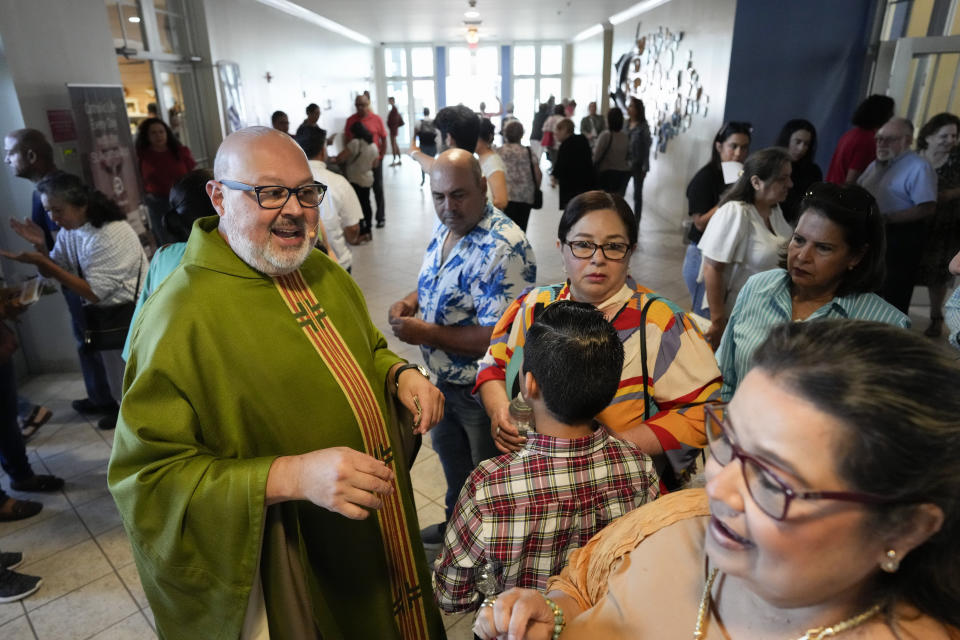 The Rev. Marcos Somarriba talks with parishioners following Mass at St. Agatha Catholic Church, which has become the spiritual home of the growing Nicaraguan diaspora, Sunday, Nov. 5, 2023, in Miami. For Somarriba's two cocelebrant priests, who include the auxiliary bishop of Managua, and many in the pews who have had to flee or were exiled from Nicaragua recently, the Sunday afternoon Mass at the Miami parish is not only a way to find solace in community, but also to keep pushing back against the Ortega regime's violent suppression of all critics, including many Catholic leaders. (AP Photo/Rebecca Blackwell)
