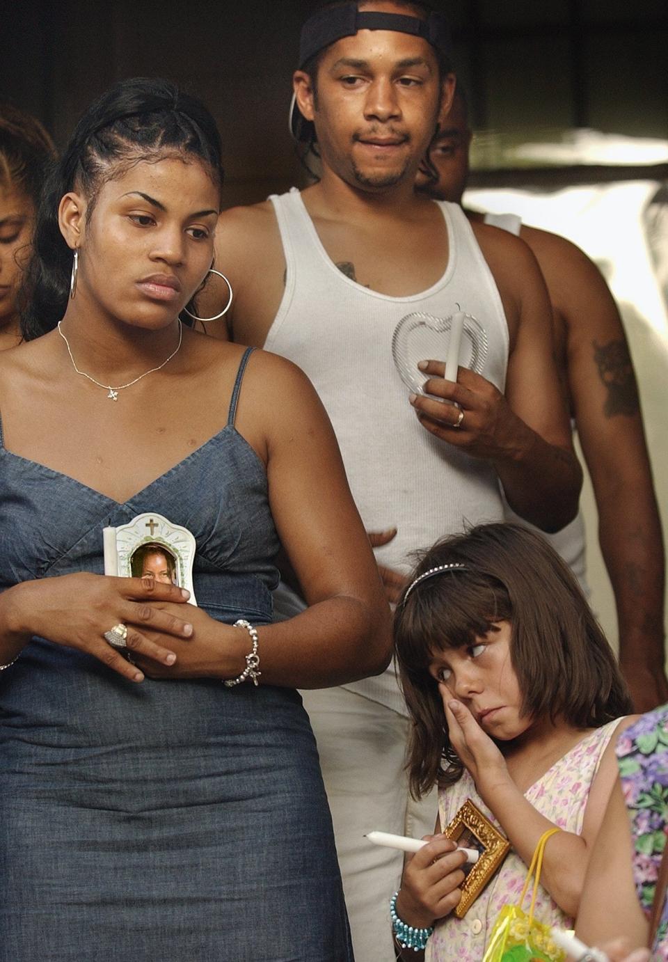 Alexis Patterson's mother, Ayanna Patterson (left), and stepfather, LaRon Bourgeois (center), attend a prayer vigil for their missing daughter. Both had been considered suspects in her disappearance and both had denied involvement.