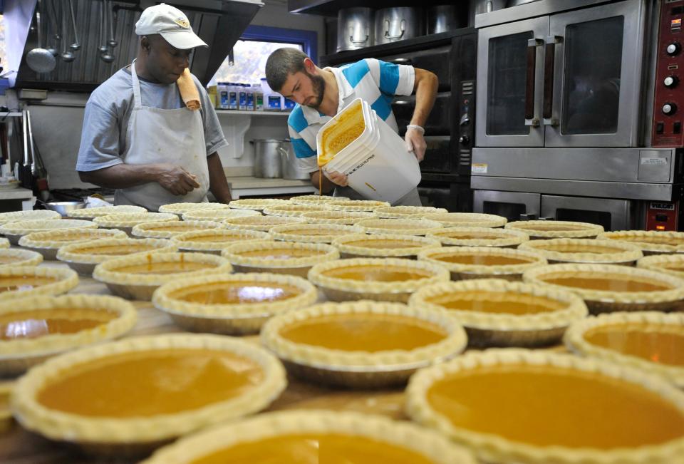 Sous chef Cleve Campbell observes as assistant baker Alexander Kukhar pours homemade pumpkin pie filing into crusts that were all hand fluted at Marion's Pie Shop. The shop cranked out 250 pumpkin in two days  pulling all-nighters for Thanksgiving special orders and for first-come, first-served holiday pies, as shown in this November photo.