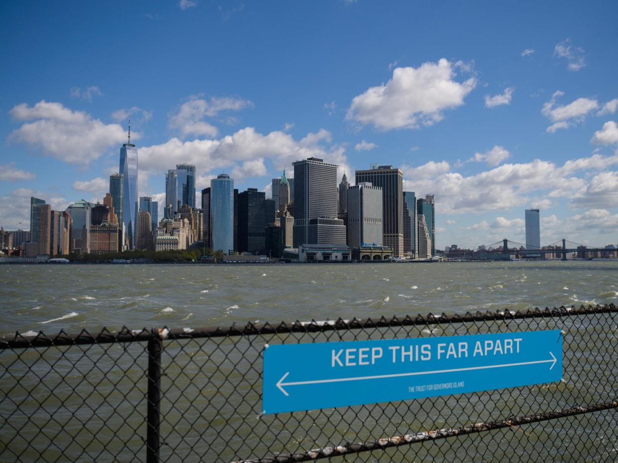 In this file photo a sign to promote social distancing is seen on Governors Island on 30 April 2021 in New York City (AFP via Getty Images)