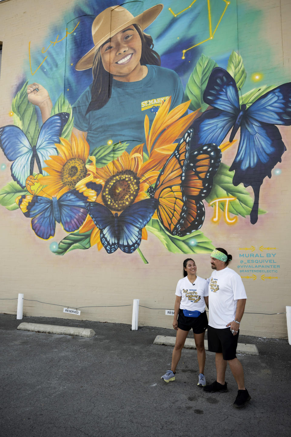 Uvalde mayoral candidate Kimberly Mata-Rubio, left, speaks with Brett Cross in front of a mural depicting Mata-Rubio's daughter, Lexi Rubio, after the second annual Lexi's Legacy Run, Saturday, Oct. 21, 2023, in Uvalde, Texas. Both Lexi Rubio and Cross' son, Uziyah Garcia, were victims of the Robb Elementary shootings in 2022. (AP Photo/Darren Abate)