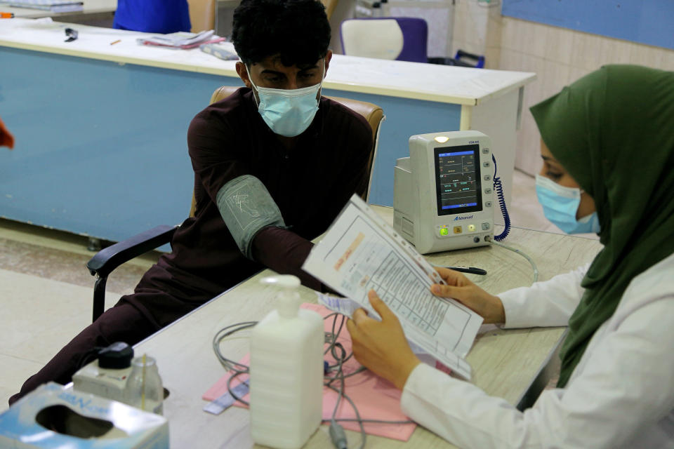 A coronavirus patient receives treatment at a hospital in Najaf, Iraq, Wednesday, July 14, 2021. Infections in Iraq have surged to record highs amid a third wave spurred by the more aggressive delta variant, and long-neglected hospitals suffering the effects of decades of war are overwhelmed with severely ill patients. (AP Photo/Anmar Khalil)