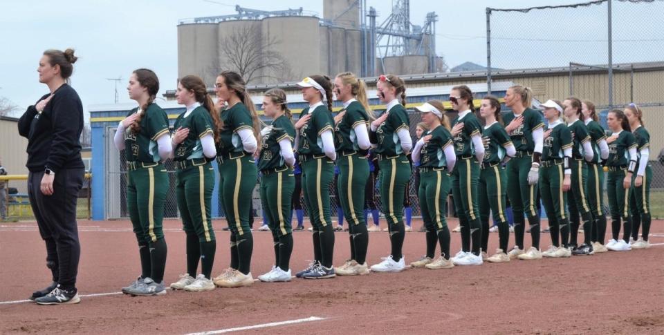 The St. Mary Catholic Central softball team lines up for the national anthem prior to Wednesday's season opener against Ida.
