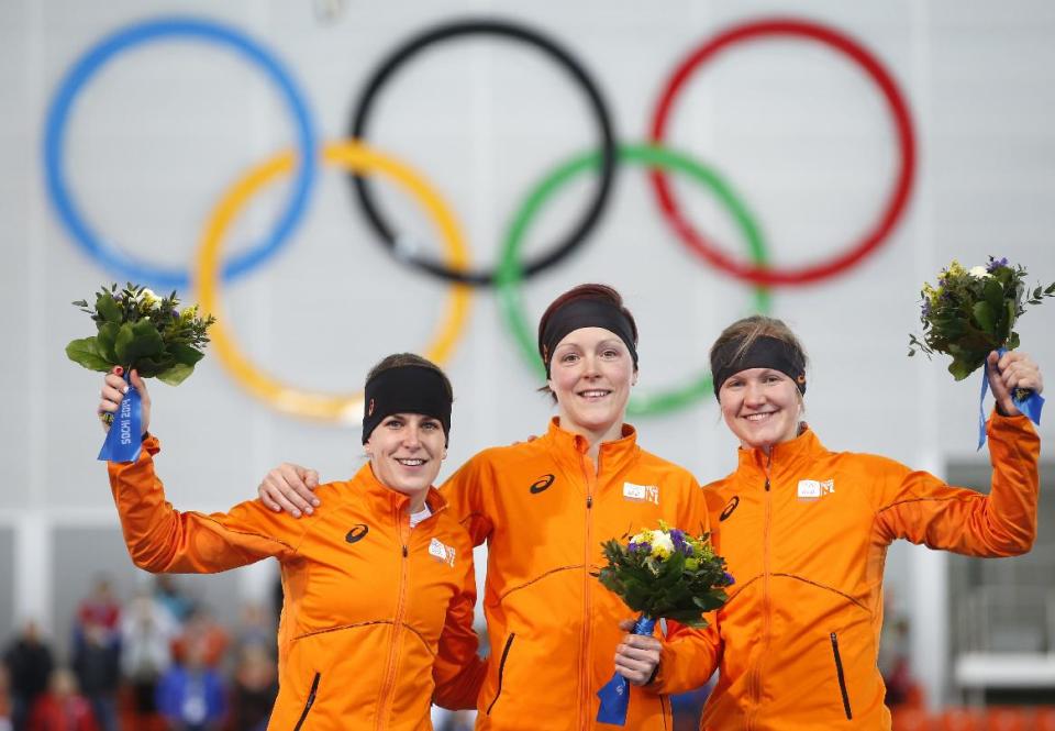 Athletes from the Netherlands, from left to right, silver medallist Ireen Wust, Gold medallist Jorien ter Mors and bronze medallist Lotte van Beek celebrate during the flower ceremony for the women's 1,500-meter speedskating race at the Adler Arena Skating Center during the 2014 Winter Olympics in Sochi, Russia, Sunday, Feb. 16, 2014. (AP Photo/Pavel Golovkin)