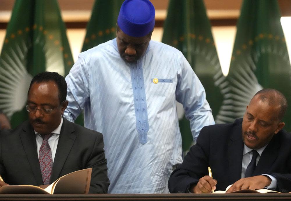 Lead negotiator for Ethiopia’s government, Redwan Hussein, left, and lead Tigray negotiator Getachew Reda, right, sign documents as Alhaji Sarjoh Bah, Director of conflict management of the African Union looks on, during the peace talks in Pretoria, South Africa, Wednesday, Nov. 2, 2022. (AP Photo/Themba Hadebe)