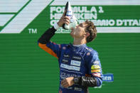 Mclaren driver Lando Norris of Britain drinks champagne from a shoe of Mclaren driver Daniel Ricciardo of Australia who won the Italian Formula One Grand Prix, at Monza racetrack, in Monza, Italy, Sunday, Sept.12, 2021. (AP Photo/Luca Bruno)