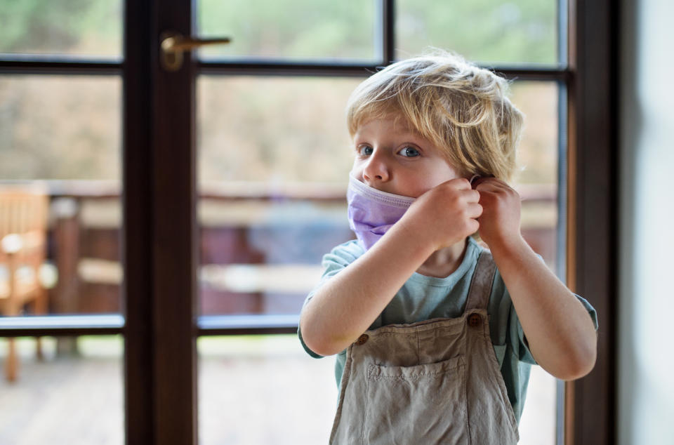 Child wearing face mask looking at camera. Pandemic restrictions could have lead to lower immunity to severe strep in children. 