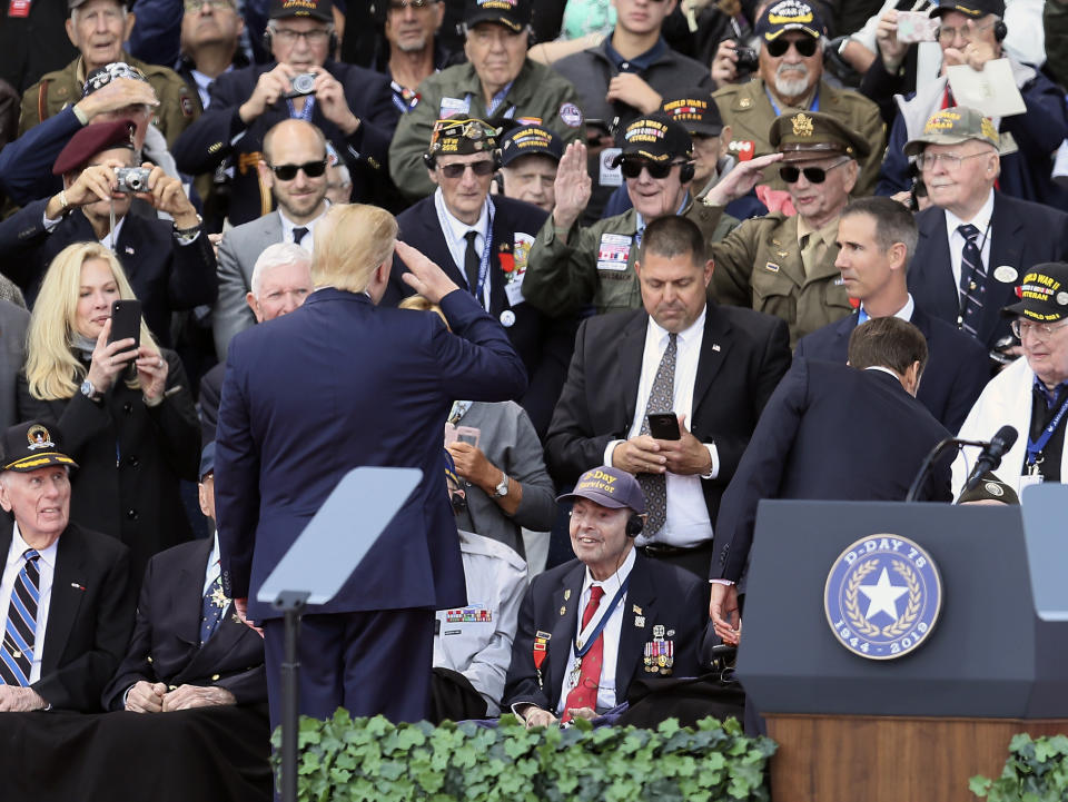 FILE - In this Thursday, June 6, 2019 file photo, President Donald Trump salutes D-Day survivor Ray Lambert during a standing ovation for him at a ceremony at the American Military Cemetery in Colleville-sur-Mer, France. Trump singled out the Army medic who was wounded four times during the June 6, 1944, landing on Omaha Beach below. Ray Lambert, the Army medic who survived multiple wounds on D-Day and was saluted by a president on the World War II battle's 75th anniversary, died on Friday, April 9, 2021. He was 100. (AP Photo/David Vincent)