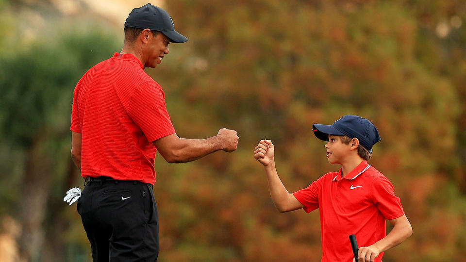 Seen here, Tiger Woods and son Charlie give one another a fist bump on the course.