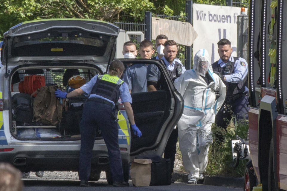 Police officers take the suspected perpetrator away in Herzogenrath, Germany, Friday, May 13, 2022. Three passengers on a regional train in Germany overpowered an Iraq-born man who wounded five people with a knife on Friday, authorities said. (Ralf Roeger/dpa via AP)