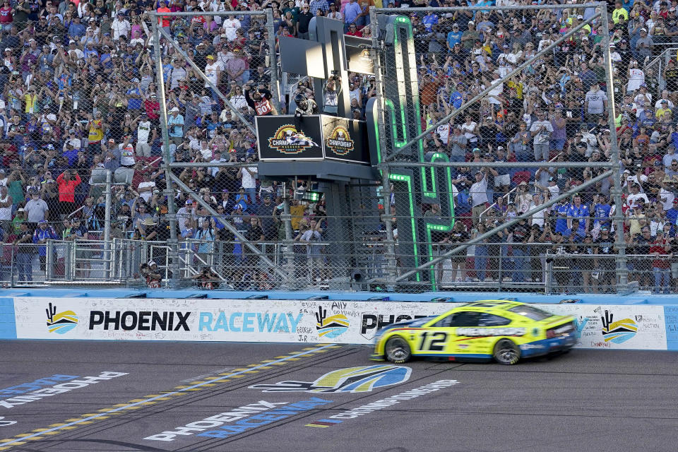 Ryan Blaney (12) takes the checkered flag to win the NASCAR Cup Series Championship Cup at Phoenix Raceway, Sunday, Nov. 5, 2023, in Avondale, Ariz. (AP Photo/Darryl Webb)