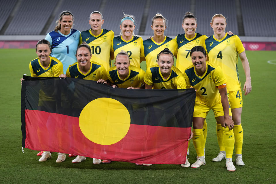 FILE - Australia players pose for a group photo with the Aboriginal flag prior to women's soccer match against New Zealand at the 2020 Summer Olympics, July 21, 2021, in Tokyo. More than any of the previous tournaments, the Women's World Cup in Australia and New Zealand has leaned into including and showcasing the Indigenous cultures of both nations. (AP Photo/Ricardo Mazalan, File)