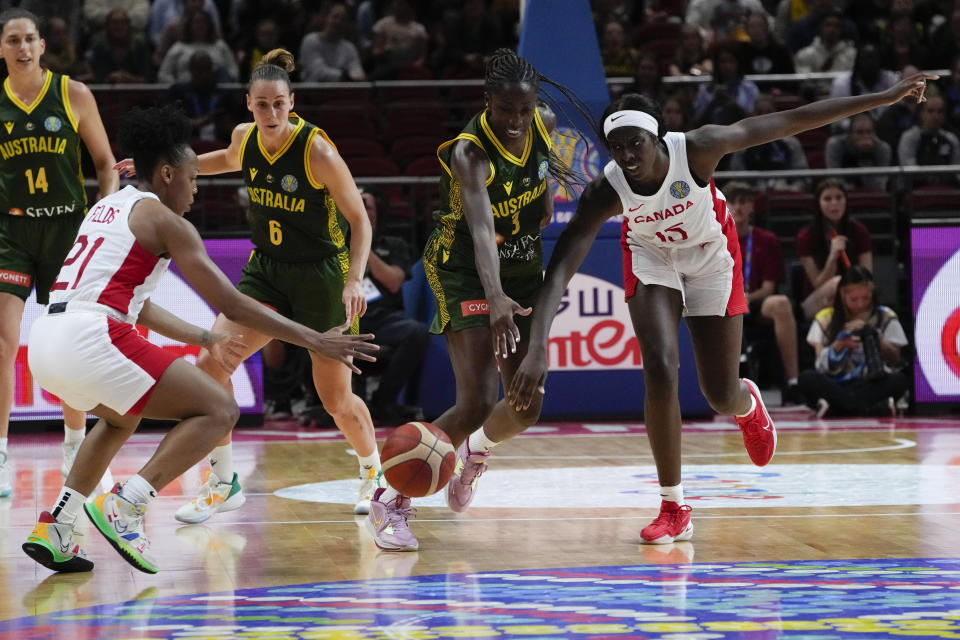 Australia's Ezi Magbegor, centre, battles for the ball with Canada's Laeticia Amihere, right, and Nirra Fields, left, during their game at the women's Basketball World Cup in Sydney, Australia, Monday, Sept. 26, 2022. (AP Photo/Mark Baker)