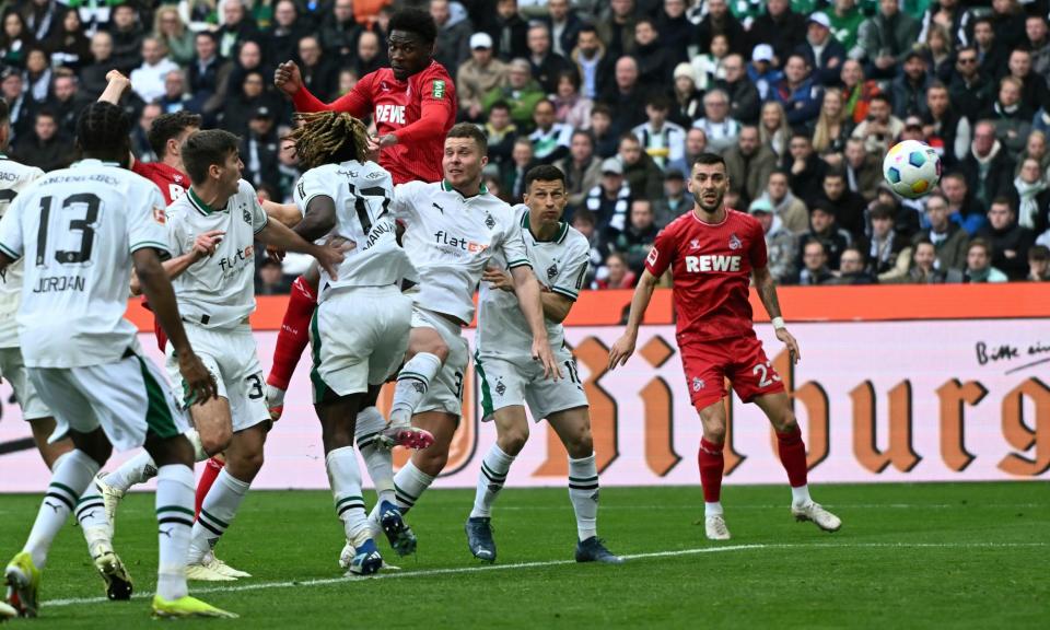 <span>Cologne's Faride Alidou climbs highest to score his side's second goal against Borussia Mönchengladbach but the visitors had to settle for a 3-3 draw.</span><span>Photograph: Federico Gambarini/AP</span>