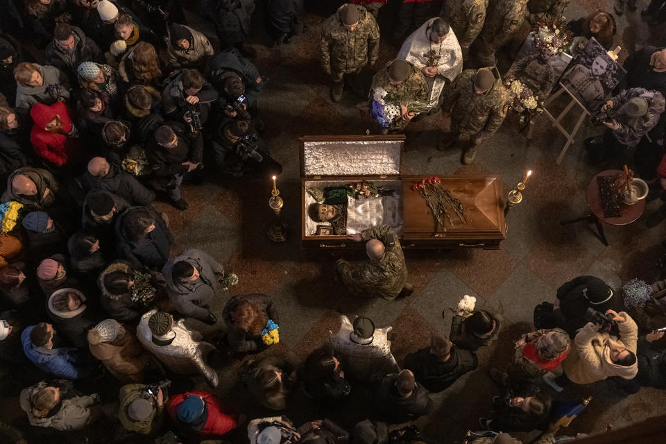 TOPSHOT - Relatives, friends, and others mourn next to the coffin of a Ukrainian poet and serviceman Maksym Kryvtsov who was killed fighting Russian troops, at the Saint Michael's Golden-Domed Monastery in Kyiv, on January 11, 2024, amid the Russian invasion of Ukraine. Several hundred Ukrainians attended the ceremony in Kyiv, despite the bitter cold, in tribute to a young Ukrainian poet and soldier Maksym Kryvtsov, call sign "Dali", whose death on the front line sparked a wave of emotion in Ukraine. Maksym Kryvtsov was killed on January 7 at the age of 33. He joined the army as a volunteer in 2022, when the Russian invasion of Ukraine began, and notably served as a machine gunner. (Photo by Roman PILIPEY / AFP) (Photo by ROMAN PILIPEY/AFP via Getty Images)