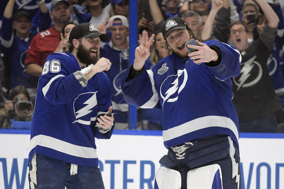 Tampa Bay Lightning right wing Nikita Kucherov (86) and goaltender Andrei Vasilevskiy (88) take selfies after the Lighting defeated the Montreal Canadiens 1-0 in Game 5 of the NHL hockey Stanley Cup finals, Wednesday, July 7, 2021, in Tampa, Fla. (AP Photo/Phelan Ebenhack)