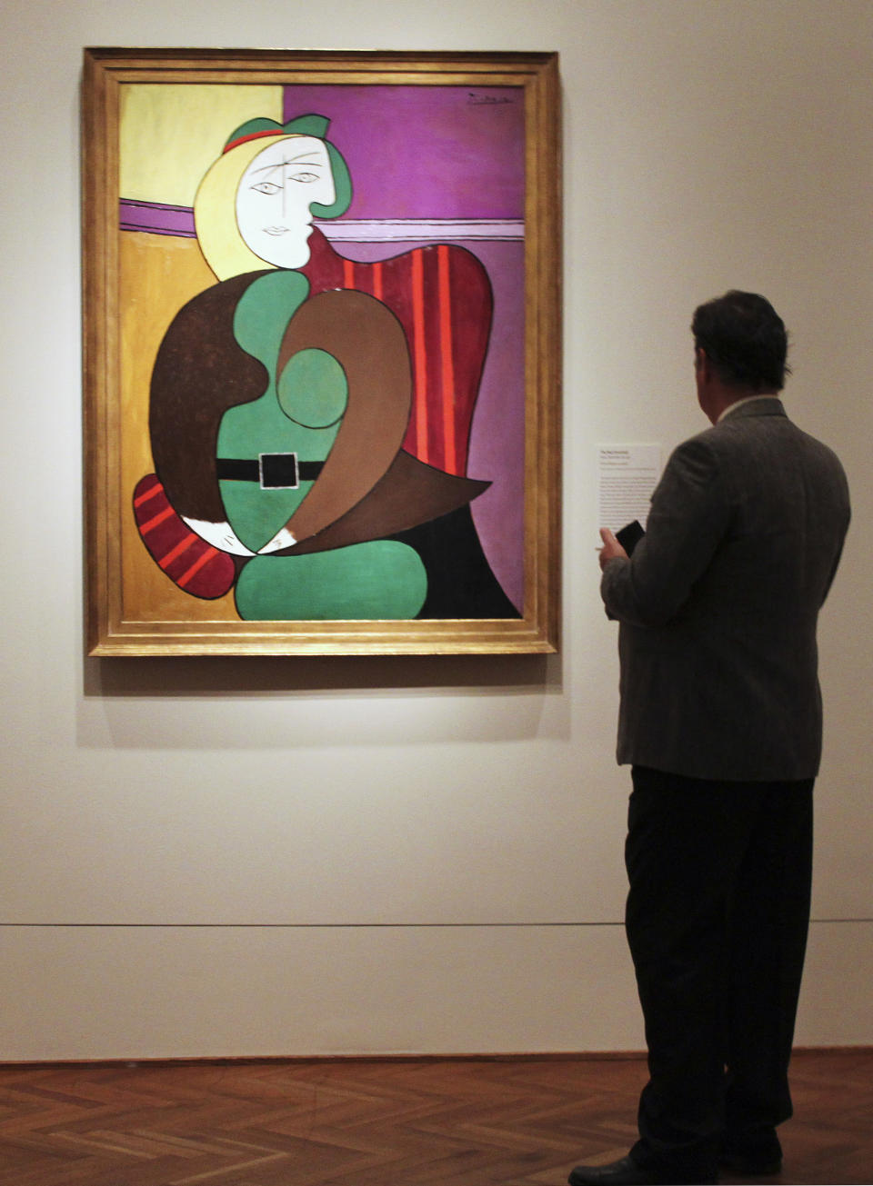 In this Feb. 14, 2013 photo, an attendee checks out Pablo Picasso's "The Red Armchair" during a media preview for "Picasso and Chicago," a major exhibition showcasing the works of Picasso at the Art Institute of Chicago. More than 250 works will be on display at the exhibit running Feb. 20-May 12, 2013. The Art Institute was the first museum in the nation to feature Picasso's work a century ago in 1913. Today's exhibit features paintings, drawings, works on paper, ceramics and sculptures. (AP Photo/Caryn Rousseau)