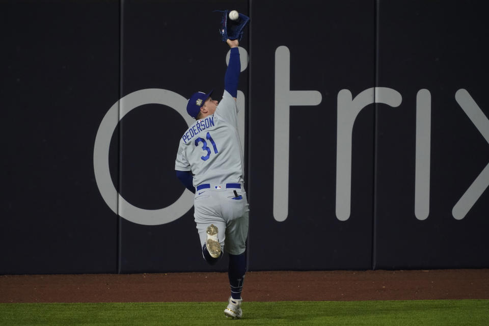 El jardinero izquierdo Joc Pederson, de los Dodgers de Los Ángeles, atrapa un elevado de Joey Wendle, de los Rays de Tampa Bay, en el séptimo inning del quinto partido de la Serie Mundial, el domingo 25 de octubre de 2020, en Arlington, Texas. (AP Foto/Tony Gutierrez)