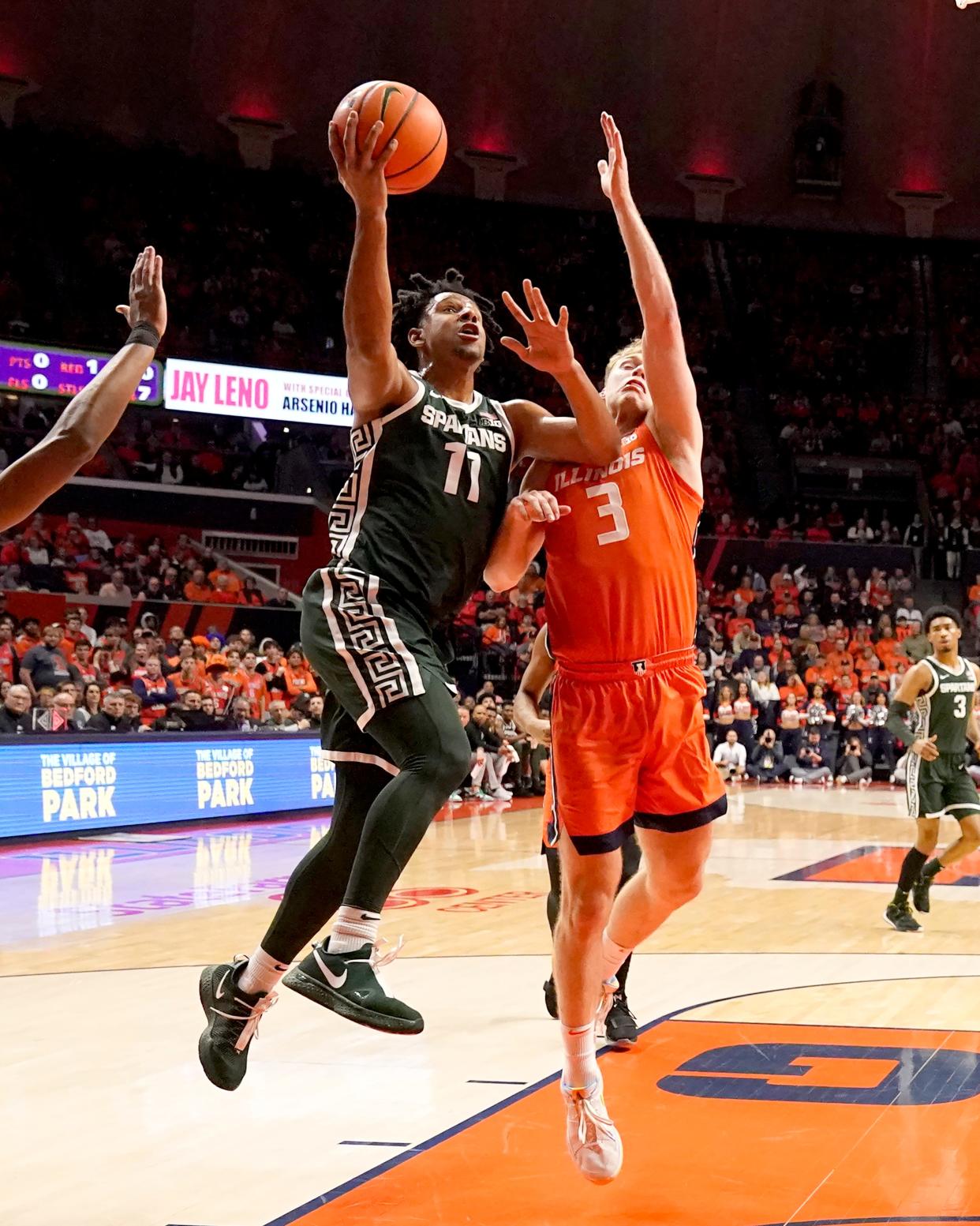 Michigan State's A.J. Hoggard (11) drives to the basket past Illinois' Marcus Domask during the first half at State Farm Arena in Champaign, Illinois, on Thursday, Jan. 11, 2024.