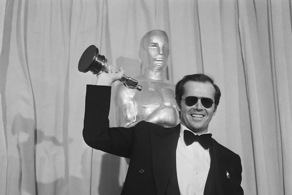 Schauspieler Jack Nicholson winkt mit seinem Oscar, den er als bester Hauptdarsteller im Film 