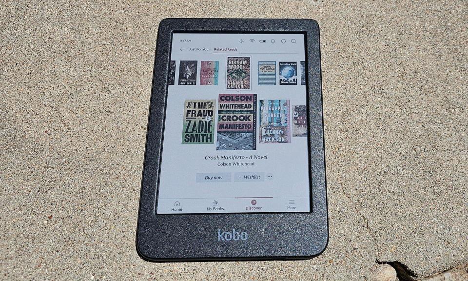 The Kobo Clara Colour sits on concrete in full sun. 