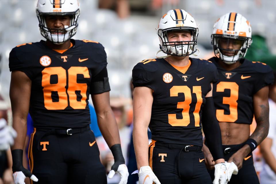 Tennessee tight end Miles Campbell (86), linebacker Nick Humphrey (31) and receiver JaVonta Payton (3) wear "dark mode" jerseys during a game against South Carolina last season.