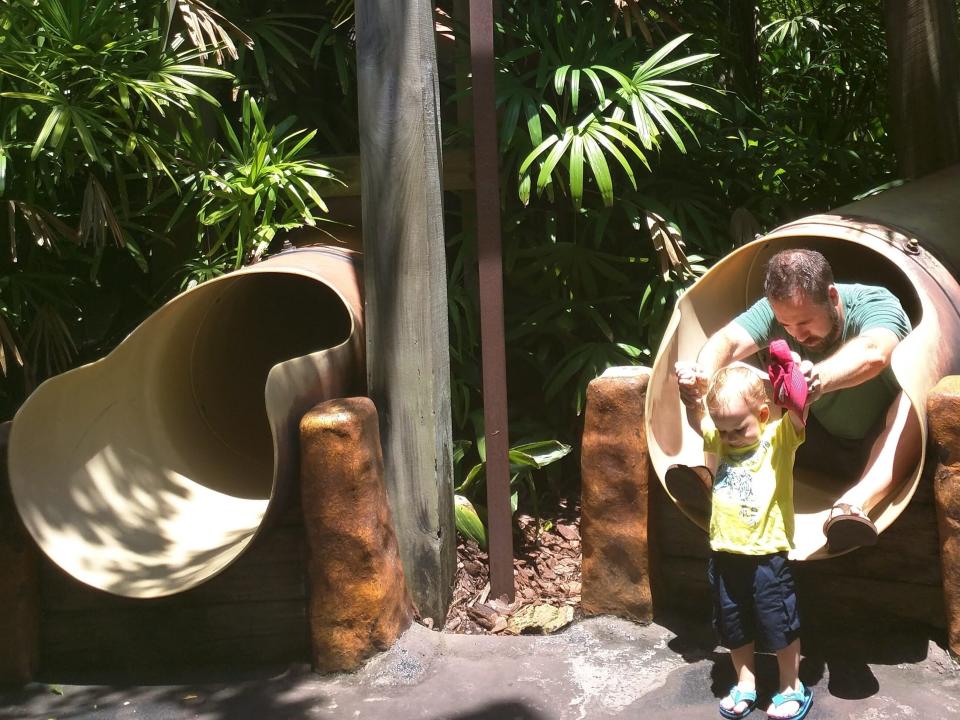 toddler and parent going down slide in jurassic park playground at islands of adventure at universal
