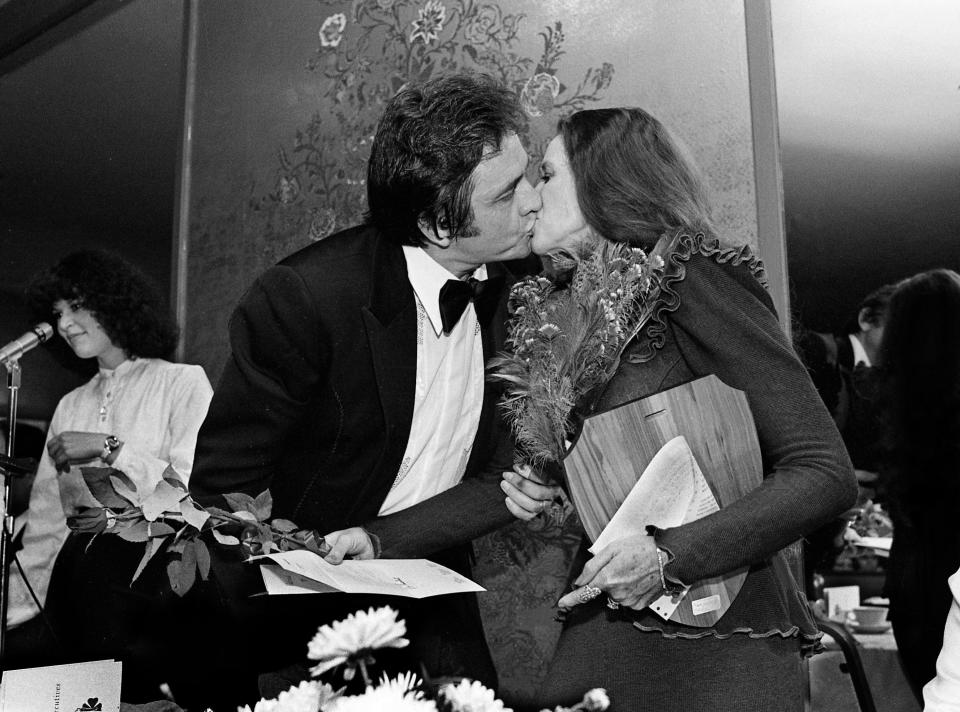 Johnny Cash, left, kisses his wife, June Carter Cash, after she was awarded the Community Service Award during the 11th annual National Women Executives awards dinner at the Hillwood Country Club April 29, 1980.